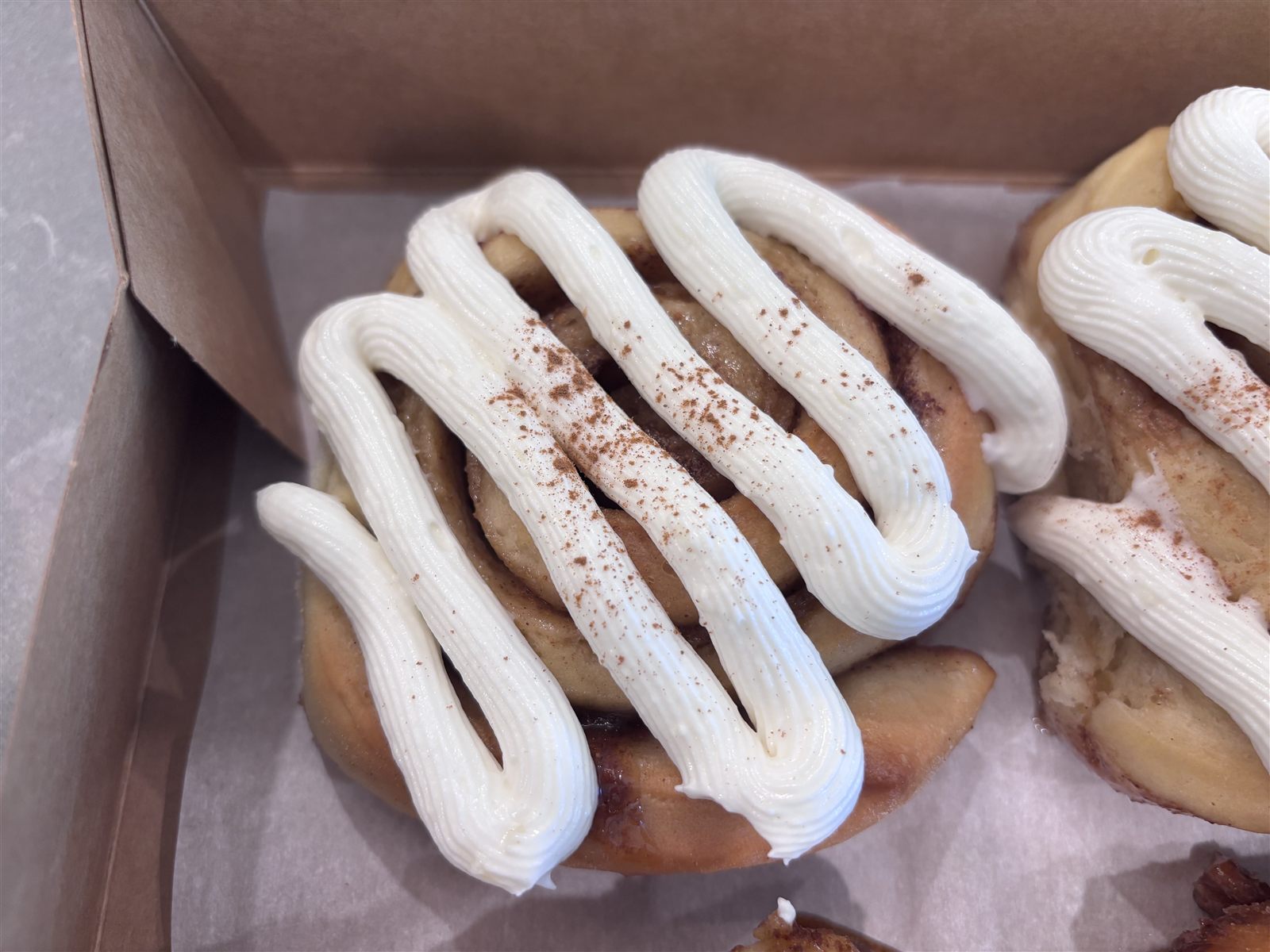 Cinnamon rolls piped with cream cheese frosting
