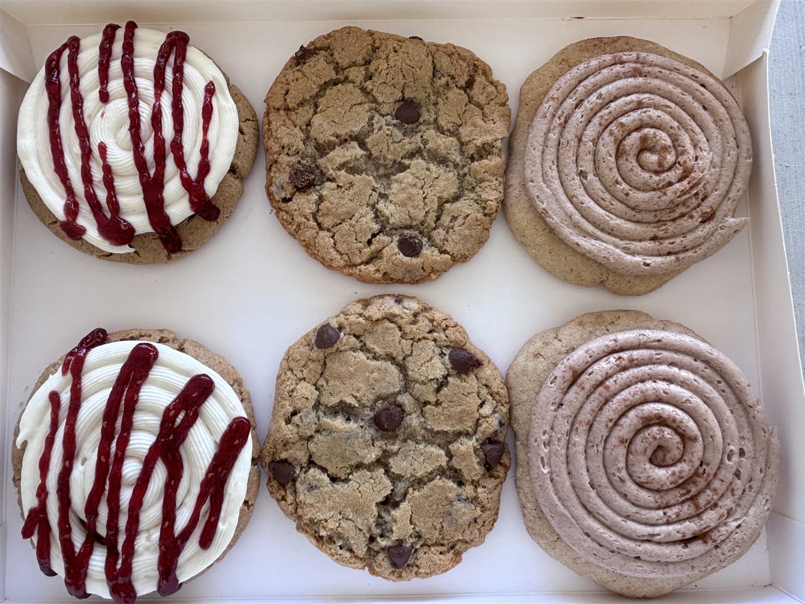 Raspberry cheesecake, chocolate chip and churro cookies boxed by the half dozen