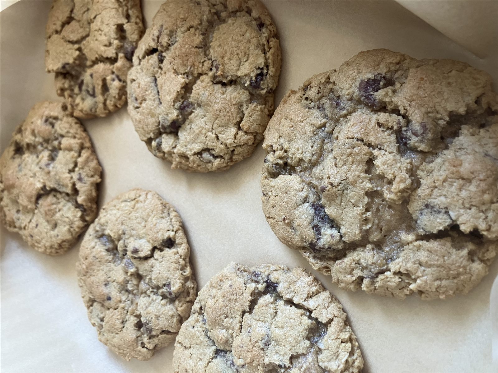 Chocolate chip cookies cooling on parchment paper