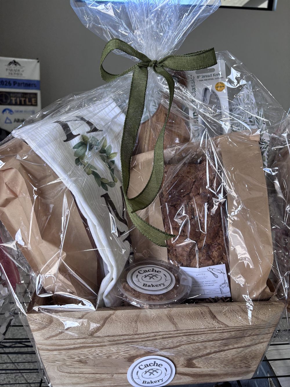 Wooden crate basket with a bread knife, tea towel, Amish cinnamon bread and a cookie